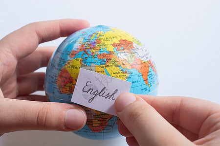 手持全球使用英文文字的纸上随笔纸班级语法世界教育语言字典地球知识全球化指导图片