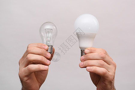 灯背景白灯泡和LED灯泡在你的手中背景