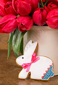 粉红郁金香和复活节兔子饼干 在木制背景木头框架季节庆典假期烘烤植物羽毛卡片妈妈们图片