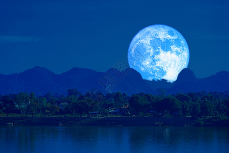 蓝月亮向后升起 在夜空中的银色云雾模糊图片