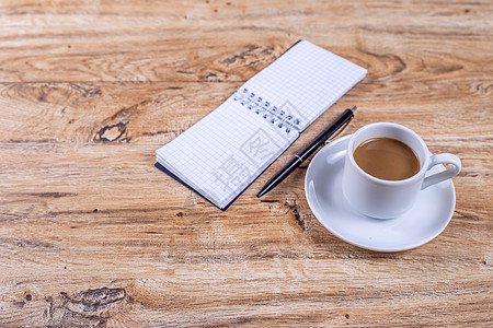 碟子上的小咖啡杯站在笔记本和笔旁边的木制桌子上写作杯子笔记文书电脑咖啡备忘录床单会议休息图片