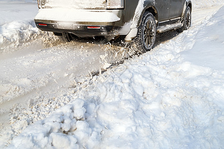 道路积雪从汽车的纺车上飞扬 汽车的车轮旋转并喷出大片雪花 它试图在湿滑的道路上获得牵引力橡皮苍蝇车辆测量冷冻喷涂加速度运输驾驶力图片