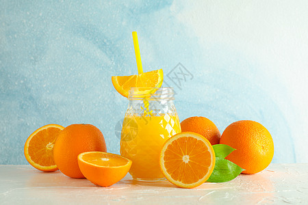 玻璃罐 有新鲜橙汁和小管 白桌上的橙子与彩色背景 文字空间 新天然饮料果汁情调桌子榨汁机早餐薄荷排毒饮食木头水果图片