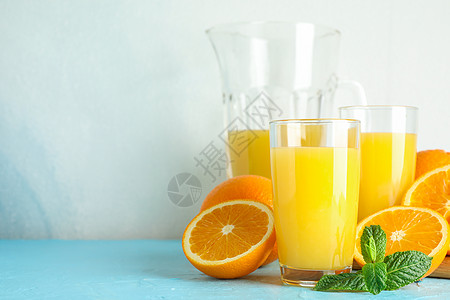 玻璃器械 薄荷和木质果汁中含有新鲜橙汁 白色背景的彩色桌上有鲜橙汁 文字空间木板热带早餐木头作品排毒饮料水果桌子饮食图片