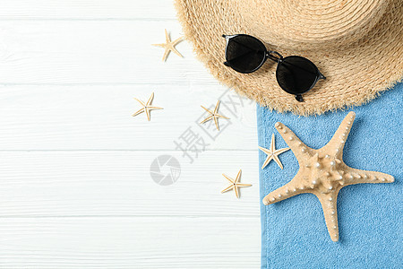 白色木制背景空间上的草帽太阳镜毛巾和海星 用于文本和顶视图 暑假背景图片