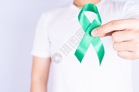 世界肾日 手握着绿丝带 了解肾病 在胸前孤立的灰色背景研究帮助捐款机构世界诊断沮丧输血压力幸存者图片