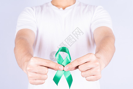 世界肾日 手握着绿丝带 了解肾病 在胸前孤立的灰色背景研究药品输血帮助诊断世界沮丧捐款活动癌症图片