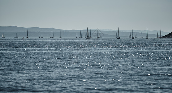 背景是帆船的美丽海景 地平线上的帆船比赛 帆船赛 激烈的比赛 鲜艳的色彩 带风车的岛屿团体天空运动海洋帆船赛蓝色海浪日落旅行杯子背景图片