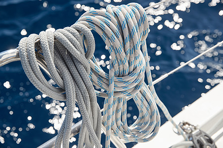 阳光明媚的天气下 帆船绳索的特写视图 桅杆上的滑轮和绳索 游艇运动 船舶设备 大海是背景晶石队长电缆破坏旅行索具绞盘滚筒天空工作图片