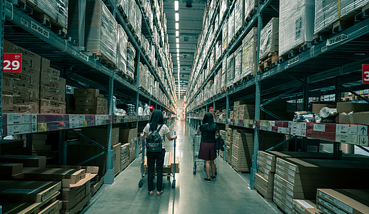 26 2020 宜家商店仓库的两名亚洲女性购物家具 一位女士在宜家商店的仓库内推着购物车 架子上的储物盒图片