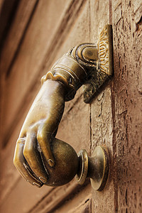 旧木制门上有手形状的金敲门机风格青铜装饰品入口黄铜木头门把手古董房子装饰图片