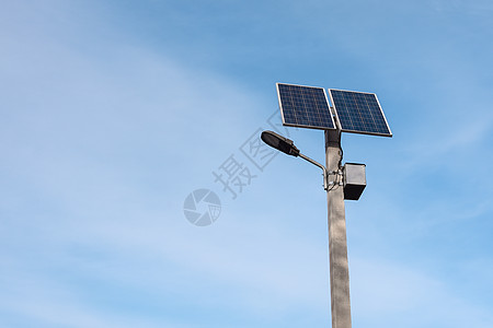 蓝色天空下灯柱上的太阳能电池板图片