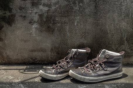 旧水泥地板上是棕色的Retro高顶旧式运动鞋帆布褐色皮革潮人男人鞋垫男士鞋类地面灯光静物橡皮图片