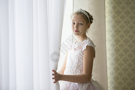 窗窗边的皇冠上美丽的女孩打开了窗帘图片