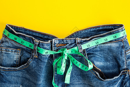 牛仔裤 黄色背面的米带瘦化饮食磁带生活药品减肥刀具肥胖测量节食保健图片