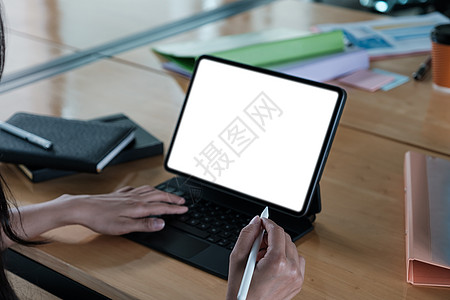 电子笔近身的女商务人士拿着数字平板电脑 在木制桌子上放空白屏幕手指地面议程监视器商务风镜阅读桌面视频购物背景