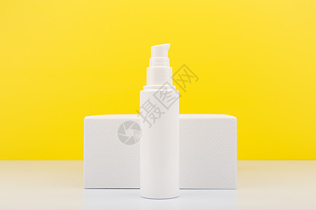 白几何讲台和光黄色背景及复制空间用于皮肤护理的面霜 润膏或凝胶图片