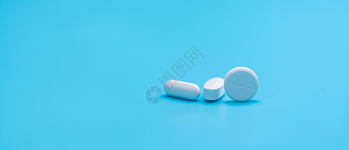 蓝色背景上的圆形白色药丸和椭圆形药丸 药店横幅 处方药 医药行业 止痛药 抗生素和抗酸药丸 制药图片