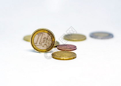 一枚欧元硬币与白色背景中突显的各种散乱硬币站在一起图片