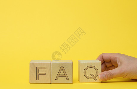 在黄色背景的木板块上输入 FAQ( 经常询问的问题)图片