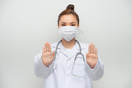 戴着医用面具 白大衣停下来 十字标志 禁止出门的严肃亚洲女医生图片