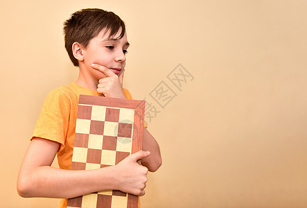男孩手握着棋盘 梦想 思考游戏 空闲的文字空间是免费的木板智力娱乐活动商务玩家智慧乐趣逻辑爱好图片