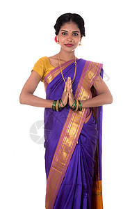 穿着传统服装的年轻印度女孩问候合十礼 欢迎 穿着传统纱丽的印度女孩 带着欢迎的表情 邀请女性成人青少年情调问候语文化奢华裙子异国图片