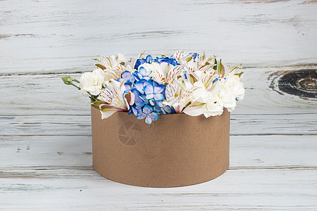 可回收纸板箱中蓝色绣球花的插花图片