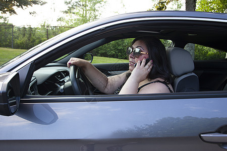 驾驶车时有加热电话的人高清图片