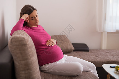 怀孕妇女已经厌倦了怀孕沙发背痛压力疼痛愤怒婴儿母亲生长分娩疾病图片