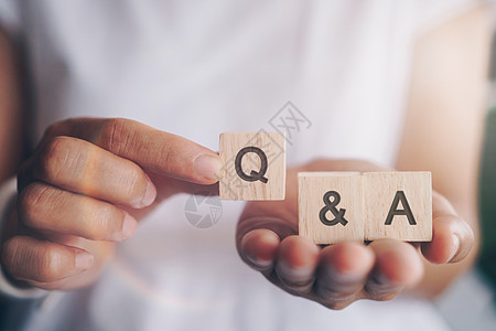 在木制立方体上 用有背景的手握着Q和字母表 问答的含义社区学习服务商业网络顾客解决方案骰子网站男人图片