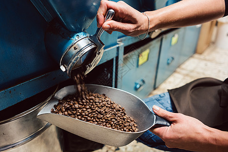 女人把咖啡豆从仓库里拿出来咖啡屋咖啡馆商品商务质量女士测试香气咖啡焙烧炉图片
