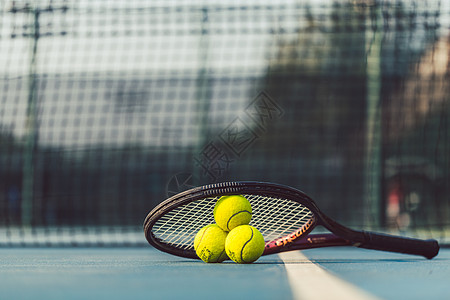 三个网球 在一个专业的电击比赛上 在丙烯蓝色表面图片