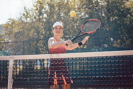 穿红运动服打网球的妇女爱好俱乐部运动场微笑运动球拍运动员网球学习法庭图片
