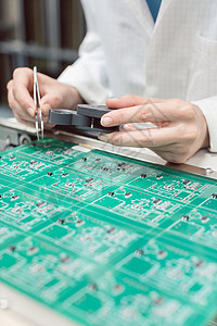 技术员将电子部件插入PDB供组装使用制造业工作操作员硬件电路板工厂工业电气工人导体板图片