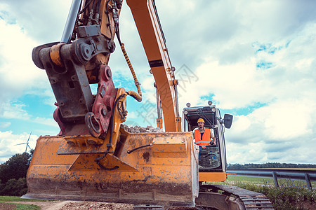 操作爬行挖土机的建筑工人挖掘机男性安全帽司机头盔土方建设项目基础设施下水道图片