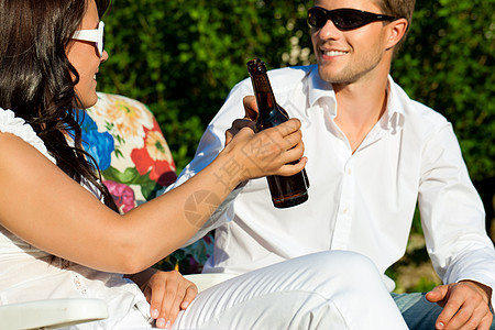 夏天喝啤酒的情侣闲暇派对男人花园啤酒女士享受时间空闲庆典背景图片