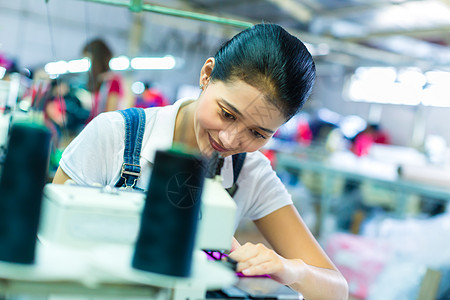 一家纺织厂的印度尼西亚裁缝织物员工劳动者缝纫机器女裁缝面料就业服装体积图片