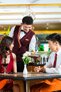 高档餐厅中国服务员在优雅餐厅或酒店吃晚饭盘子成人周年桌子玻璃服务庆典团体服务器男人背景
