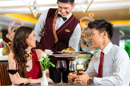 高档餐厅中国服务员在优雅餐厅或酒店吃晚饭服务用餐派对周年食物男人夫妻成人服务器已婚背景