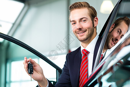 汽车经销业中的年轻人或汽车经销商白色陈列室商业代理商职业咨询钥匙销售量工作男性图片