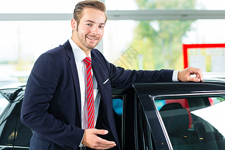 汽车经销业中的年轻人或汽车经销商推销员代理商销售量工作套装钥匙男人咨询白色零售图片