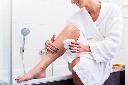 坐在浴缸边边上的女人 在腿上涂乳液静脉曲张修脚奶油洗手间皮肤卫生瓷砖卫生间虚荣产品图片