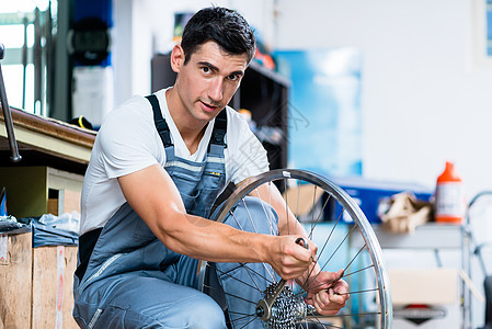 男子作为在车间工作的自行车机械工车轮商业工具职业商店机械男人服务维修齿轮图片
