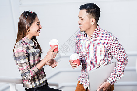休息期间在喝咖啡时说话的男女青年男子与妇女图片
