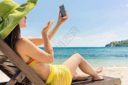 迷人的年轻女士 通过海滩上的自拍 传递爱情信息 在沙滩上图片
