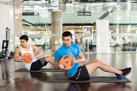 执着的年轻人在俄罗斯做曲折班级重量俱乐部朋友橙子中心健康腹肌重板运动图片