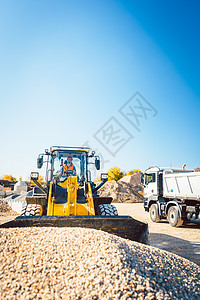 建筑工人用轮式搬运车从事土木工程职业土方工人司机平台卡车石头货物输送碎石图片