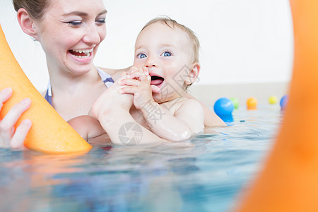 母亲对婴儿在游泳池里玩耍感到开心 妈妈们也很高兴图片