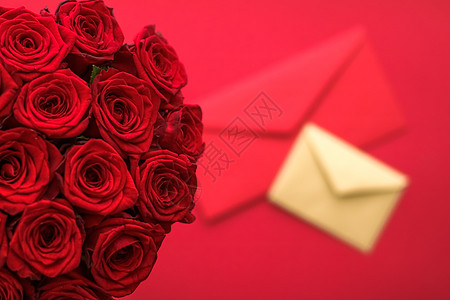 情人节的情书和送花服务 红色背景的豪华红玫瑰花团和纸信封红底卡片玫瑰爱情邮件平铺邀请函通讯展示邮政礼物图片